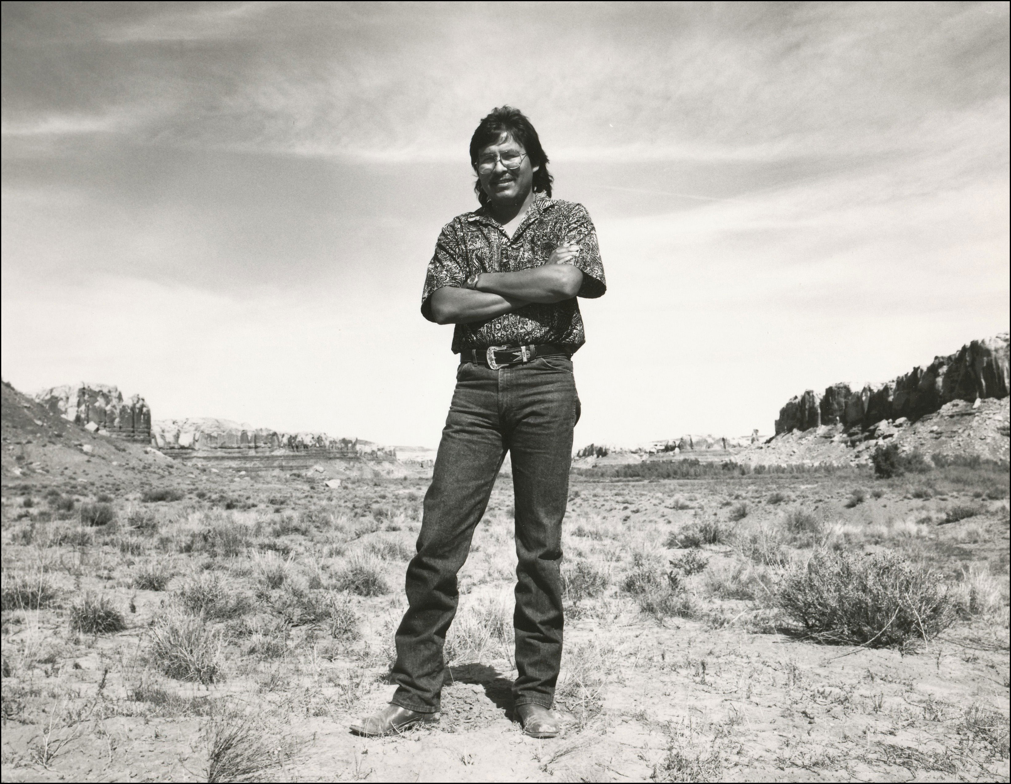 Native man state legislator standing with arms folded out in dry area