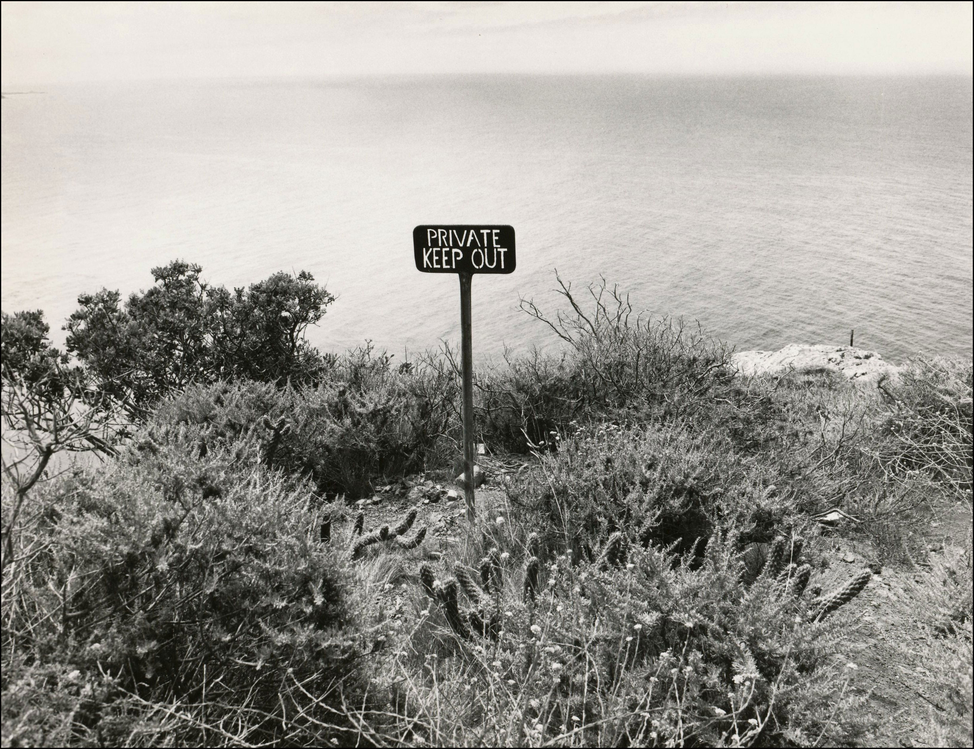 Small wooden private property sign on the edge of the coastline.