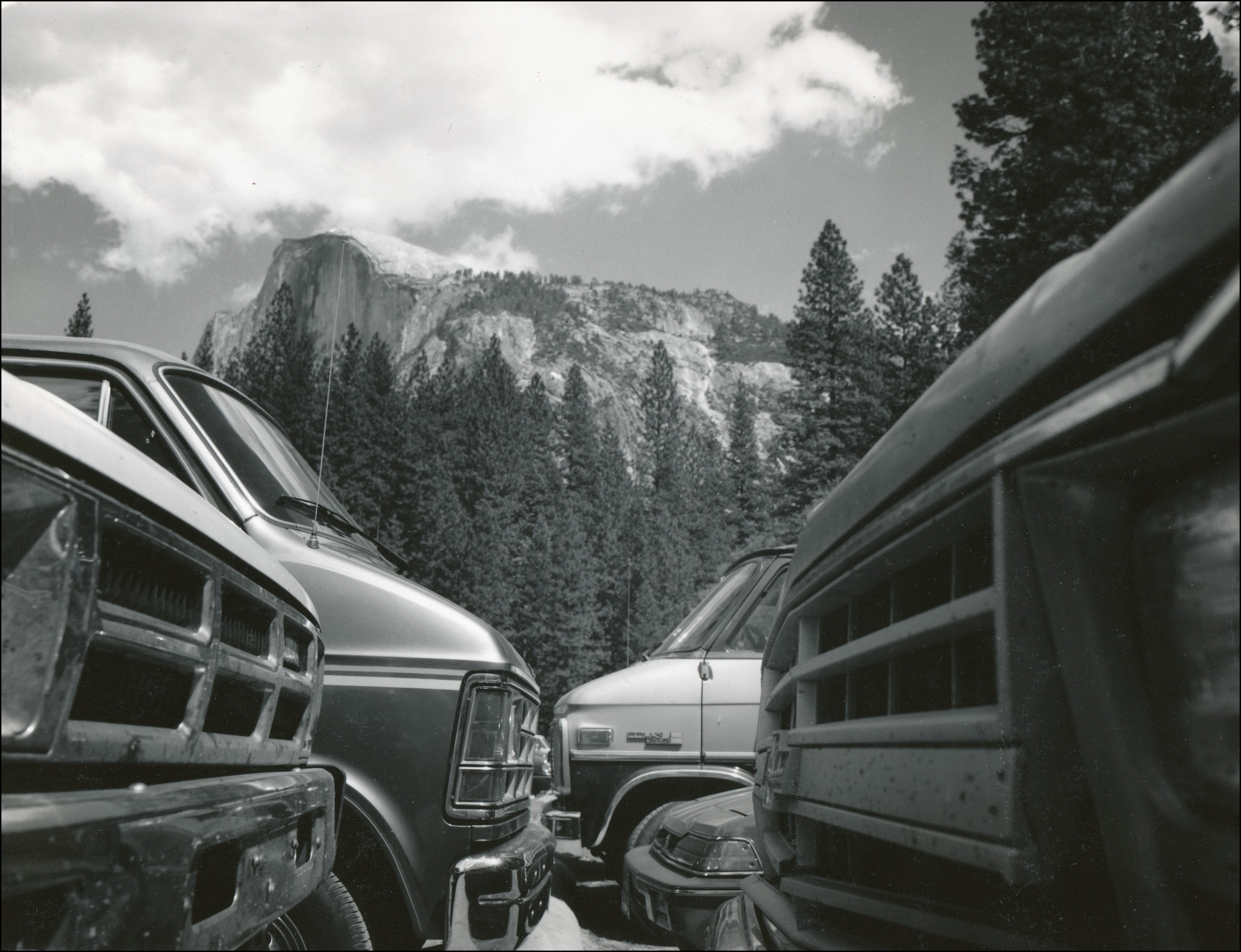 Parking lot full of cars with view of half dome in background